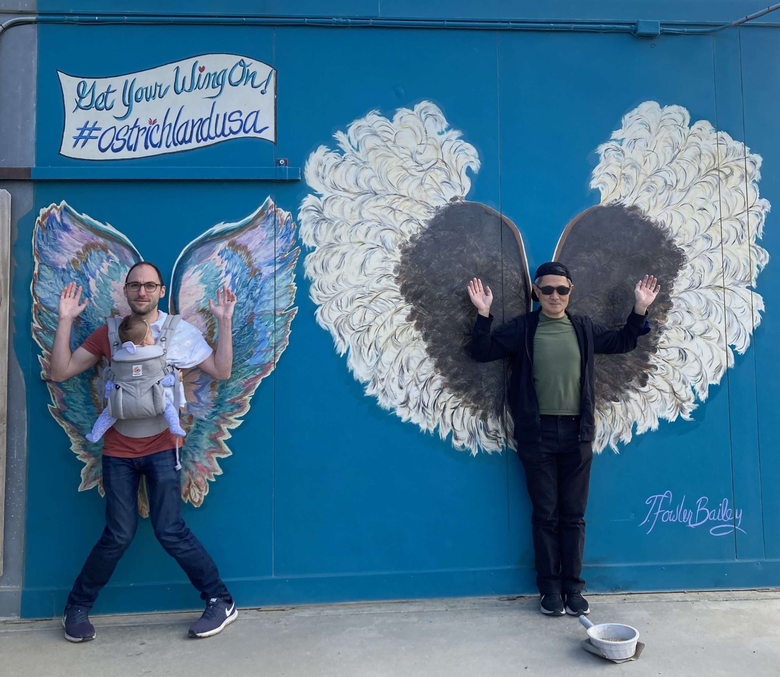 Me, my daughter and my father-in-law making poses in front of wings art