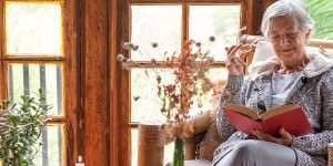 Senior woman relaxing at home reading a book