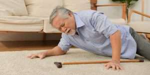 Senior man fallen over laying on the floor at home