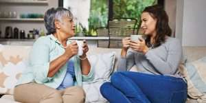 Senior woman sat on the couch talking to her daughter