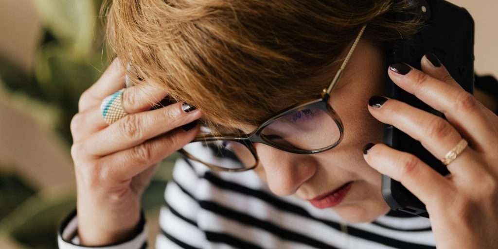 Woman on the phone and looking anxious with her head down