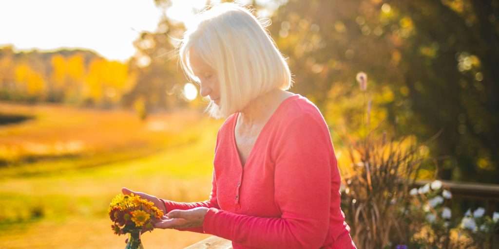 Senior woman outside tending to flowers