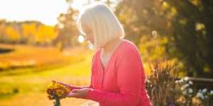 Senior woman outside tending to flowers