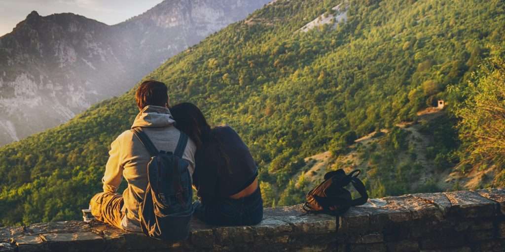 Couple sitting together enjoying a scenic mountain view at sunset