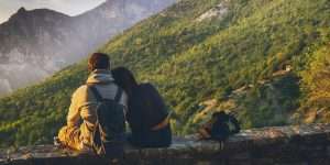Couple sitting together enjoying a scenic mountain view at sunset